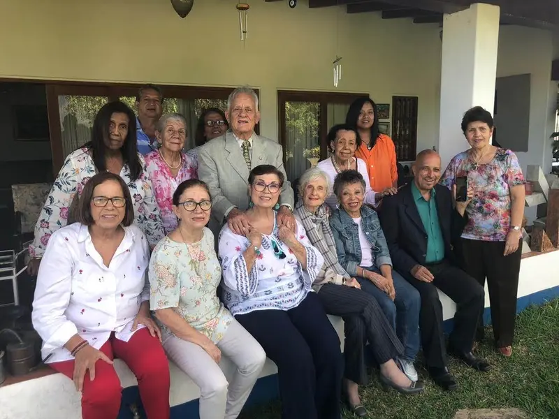 A group spanning several generations together on the porch of a house
