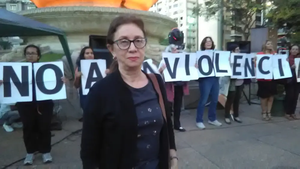 A group of women holding letters that spell out «No a la violencia» (No to violence) at an outdoor gathering in Caracas